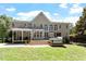 Large backyard featuring a covered porch, multiple windows, hot tub, and ample outdoor space at 312 Flint Point Ln, Holly Springs, NC 27540