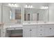 Bathroom featuring double sinks, two large mirrors, white cabinetry and stylish fixtures offering plenty of space at 312 Flint Point Ln, Holly Springs, NC 27540