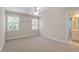 Spacious bedroom featuring neutral walls, carpet flooring, and two windows for ample natural light at 312 Flint Point Ln, Holly Springs, NC 27540
