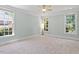 Spacious bedroom with carpeted floors, neutral paint, and ample natural light from the large windows at 312 Flint Point Ln, Holly Springs, NC 27540
