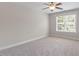 Bedroom with carpeting, neutral walls, ceiling fan, trim, and window with natural light at 312 Flint Point Ln, Holly Springs, NC 27540