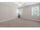 Carpeted bedroom with ceiling fan, neutral walls, ample natural light, and white trim at 312 Flint Point Ln, Holly Springs, NC 27540