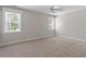Bright bedroom features neutral paint, two windows, and carpet flooring providing a comfortable and inviting space at 312 Flint Point Ln, Holly Springs, NC 27540