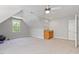 Large bonus room with neutral carpet, a bar area, and windows for natural light, perfect for entertaining or relaxing at 312 Flint Point Ln, Holly Springs, NC 27540
