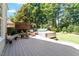 Backyard deck featuring a hot tub, stylish seating, lush greenery, and private outdoor space at 312 Flint Point Ln, Holly Springs, NC 27540
