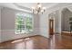 Bright dining room with hardwood floors, elegant lighting, and large windows at 312 Flint Point Ln, Holly Springs, NC 27540