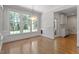 Sunlit dining area with large windows, hardwood floors, and contemporary lighting fixture at 312 Flint Point Ln, Holly Springs, NC 27540