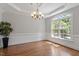 Bright dining room with hardwood floors, elegant lighting, and large windows at 312 Flint Point Ln, Holly Springs, NC 27540