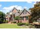 Charming two-story brick home with mature trees, lush green lawn, and inviting curb appeal at 312 Flint Point Ln, Holly Springs, NC 27540