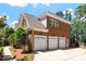 Side view of a three-car garage with brick exterior, complementing the main house at 312 Flint Point Ln, Holly Springs, NC 27540