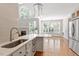 Well-lit kitchen features white cabinets, countertop seating, stainless steel appliances, and open floorplan at 312 Flint Point Ln, Holly Springs, NC 27540