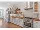 Stylish kitchen with stainless steel appliances, butcher block countertops, floating shelves, and white subway tile backsplash at 312 Flint Point Ln, Holly Springs, NC 27540