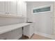 Functional laundry room offers built-in cabinets, ample counter space, stainless steel sink, and a window at 312 Flint Point Ln, Holly Springs, NC 27540