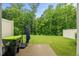 Spacious, well-maintained backyard with lush green grass, privacy fence, patio and wooded views at 3215 Retama, New Hill, NC 27562