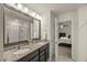 Bathroom featuring double sinks, granite counters, dark cabinets, and a glass-enclosed shower at 3215 Retama, New Hill, NC 27562
