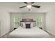 Bright bedroom with a large bed, ceiling fan, and natural light from dual windows at 3215 Retama, New Hill, NC 27562