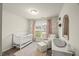 A staged Bedroom featuring soft pink accents, crib, changing table, and natural light at 3215 Retama, New Hill, NC 27562
