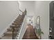Grand entryway showcasing a staircase with carpeted steps and a wrought iron banister at 3215 Retama, New Hill, NC 27562