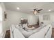 Bright living room featuring a large sectional sofa and a decorative ceiling fan at 3215 Retama, New Hill, NC 27562