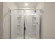Modern shower with bright tile, glass doors, and a shower head at 3215 Retama, New Hill, NC 27562