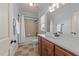 Well-lit bathroom with a shower-tub combination and a dark wood vanity with a white sink at 3306 Storybook Ln, Raleigh, NC 27614