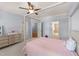 Bright bedroom featuring a four-poster bed, light blue walls, and access to a bathroom at 3306 Storybook Ln, Raleigh, NC 27614