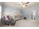 Bright bedroom with a crib, chair, board and batten, and an open door to the bathroom at 3306 Storybook Ln, Raleigh, NC 27614