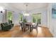 Bright dining room with hardwood floors, large windows, and neutral color palette at 3306 Storybook Ln, Raleigh, NC 27614
