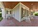 Inviting covered porch with brick flooring, rocking chairs, and outdoor seating area at 3306 Storybook Ln, Raleigh, NC 27614