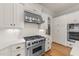 Close-up of a kitchen featuring white cabinets, a subway tile backsplash, and stainless steel appliances at 3306 Storybook Ln, Raleigh, NC 27614