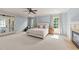 Spacious main bedroom with a fireplace, two windows, a ceiling fan, and access to the balcony at 3306 Storybook Ln, Raleigh, NC 27614