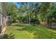 Large backyard with lush greenery, framed by mature trees and a wood fence at 3317 Harden Rd, Raleigh, NC 27607