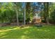 Spacious backyard with lush greenery, tall trees, and a charming brick structure at 3317 Harden Rd, Raleigh, NC 27607