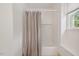 Bright bathroom showcasing a tub with shower and window with natural light at 3317 Harden Rd, Raleigh, NC 27607