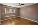 Bedroom with hardwood floors, a ceiling fan, and a large window at 3317 Harden Rd, Raleigh, NC 27607