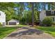 Long driveway leading to a detached garage and a backyard with mature trees at 3317 Harden Rd, Raleigh, NC 27607