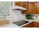 A clean kitchen with wood cabinets, light countertops, and modern electric stove top at 3317 Harden Rd, Raleigh, NC 27607