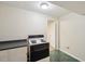 A small kitchenette with a white stove, cabinets and black countertop at 3317 Harden Rd, Raleigh, NC 27607