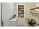 Bright laundry room with stackable washer/dryer, storage shelves, and neutral decor at 3317 Harden Rd, Raleigh, NC 27607