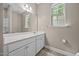 Neutral bathroom featuring an undermount sink, window, and medicine cabinet at 35 Clubhouse Dr, Youngsville, NC 27596