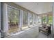 Bright sunroom with large windows offering scenic views of the outdoors and wicker seating at 35 Clubhouse Dr, Youngsville, NC 27596