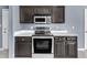A well-equipped kitchen with black cabinets, stainless steel microwave and electric range at 3604 Rivermist Dr, Raleigh, NC 27610