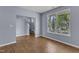 Light-filled living room features wood-look floors, staircase, and large window with neighborhood views at 3604 Rivermist Dr, Raleigh, NC 27610