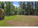 Spacious backyard with brick house, shed, mature trees, and grass at 37 Weeping Willow Ln, Lillington, NC 27546