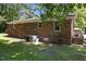 Brick home exterior featuring a grassy backyard and mature trees at 37 Weeping Willow Ln, Lillington, NC 27546