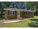 Classic brick home featuring a charming entrance with brick steps and mature shade trees at 37 Weeping Willow Ln, Lillington, NC 27546
