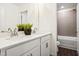 Bright bathroom with double vanity, white cabinets, and open doorway to the water closet and tub/shower at 380 Shelby Meadow Ln, Angier, NC 27501