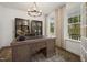 This is a home office with a large desk, decorative shelving, and large windows offering plenty of natural light at 380 Shelby Meadow Ln, Angier, NC 27501