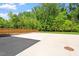 Expansive backyard featuring a concrete patio, fence, and mature trees at 3934 Old Chapel Hill Rd, Durham, NC 27707