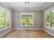 Bright dining room with modern light fixture and large windows at 3934 Old Chapel Hill Rd, Durham, NC 27707